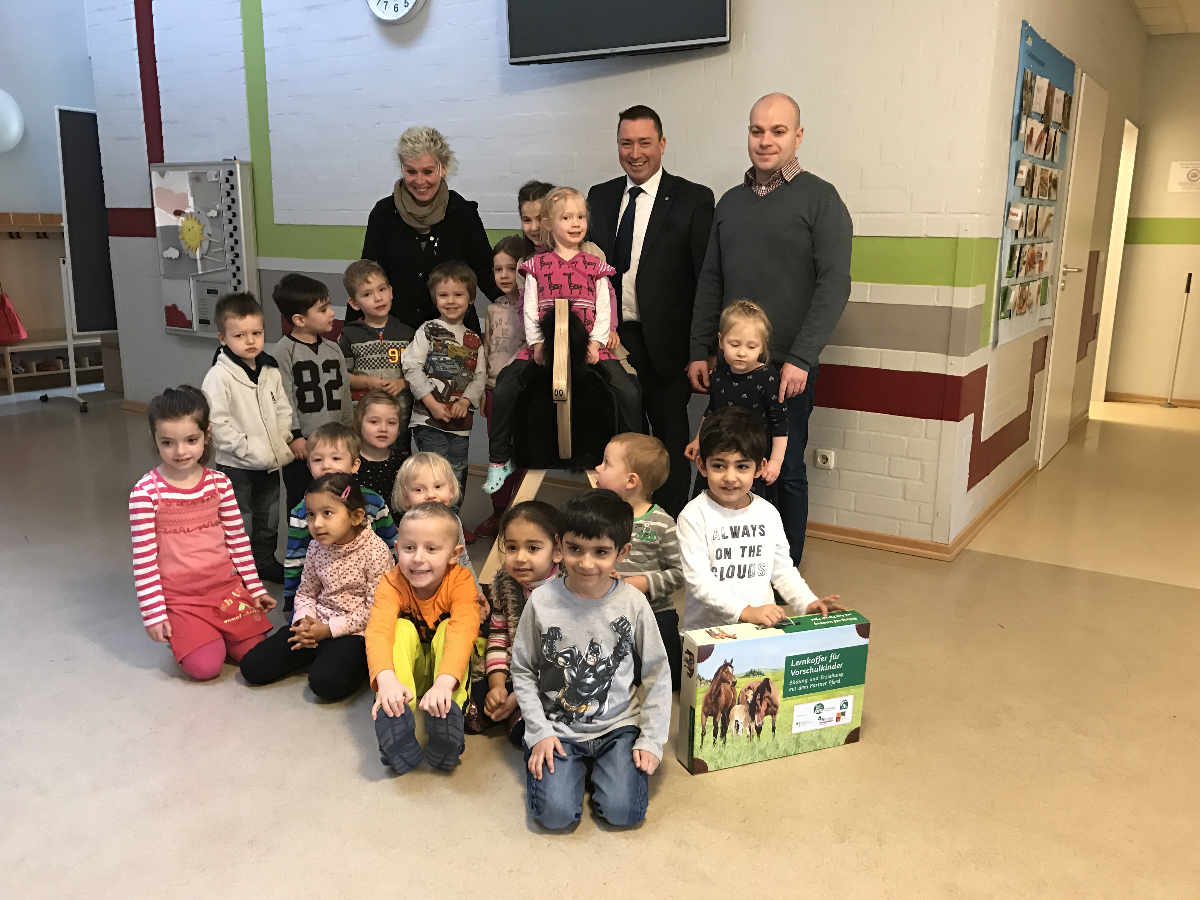 Bildunterschrift: Strahlende Kinderaugen in der Kita Baumacker: Volker Seidel (Mitte) überreichte Holzpferd und Lernkoffer an die Gruppenleiter Doris Radtke und Lukas Hildebrandt. Foto: Bankhaus August Lenz