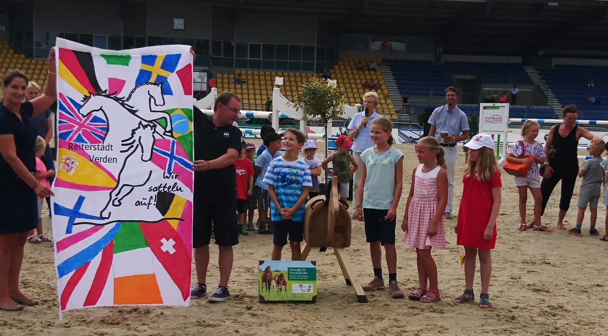 Kindertag Verden International 2018 - Hannoveraner Verband - Flagge, Kinder und Holzpferde Kindertag Verden International 2018 - Hannoveraner Verband - Flagge, Kinder und Holzpferde